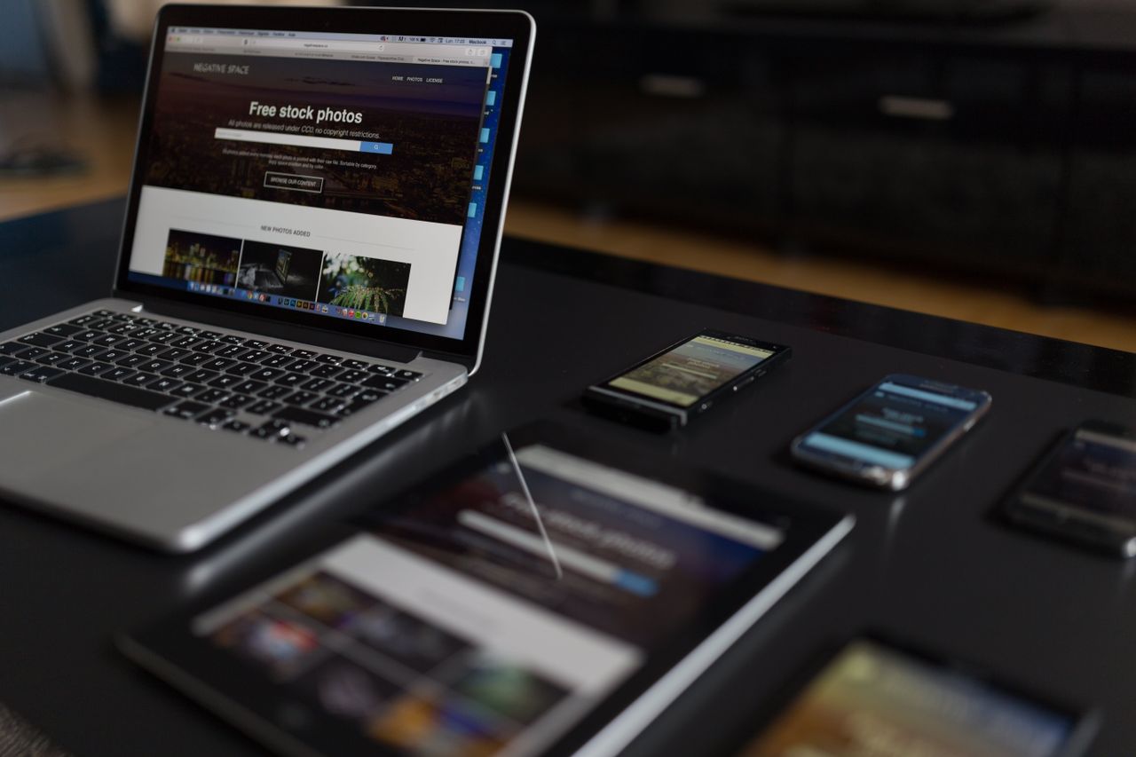 Un espace de travail contemporain mettant en scène un ordinateur portable, une tablette et des smartphones, idéal pour un usage technologique et freelance.